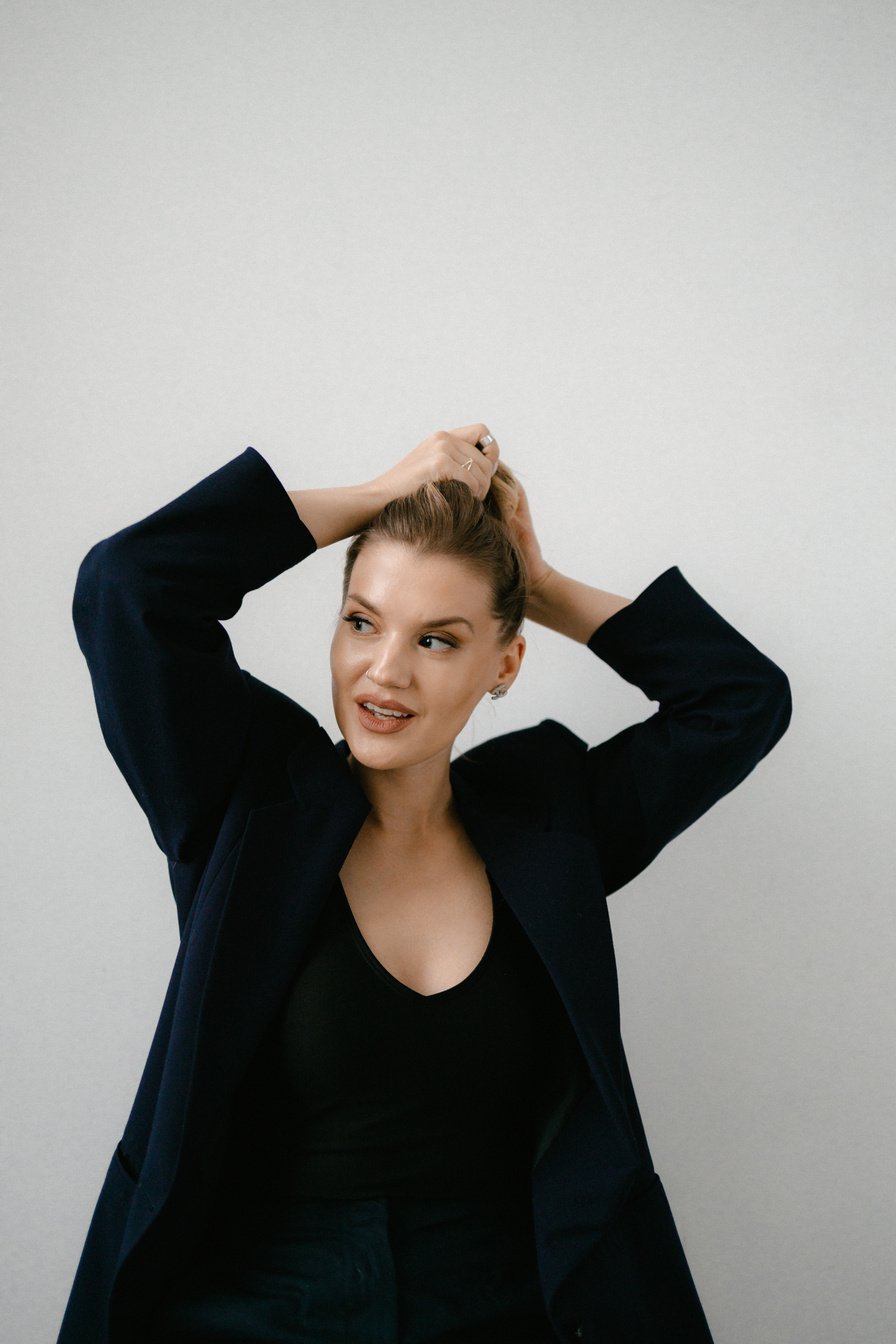 A Woman in Black Blazer with Her Hands on Her Hair